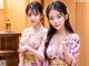 A couple of women in kimonos standing next to each other.