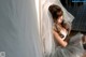 A woman in a wedding dress sitting on the floor.