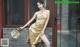 A woman in a yellow dress posing for a picture.